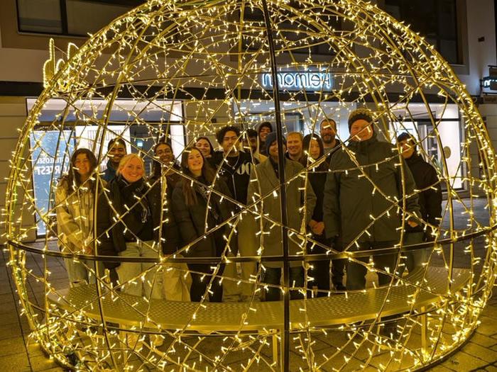 students with holiday lights all smiling